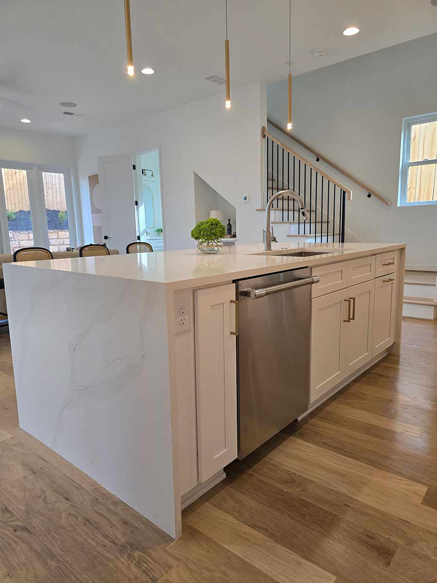 Open concept kitchen with marble waterfall island and engineered hardwood floors